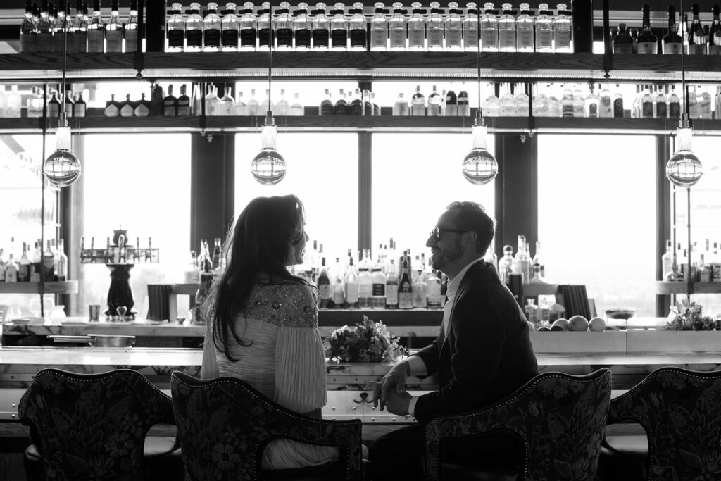 Couple sits at the bar at Klocke Estate on their wedding day.