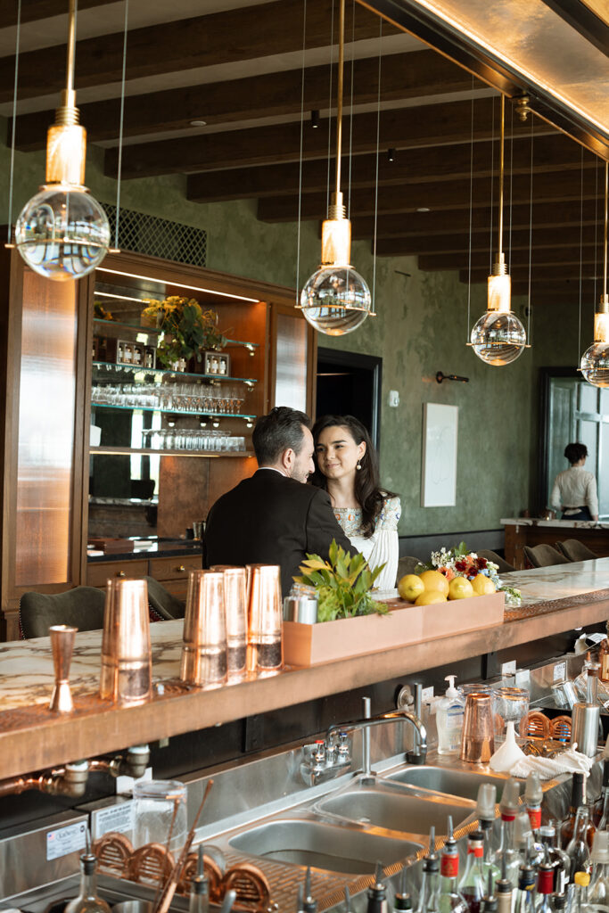 Couple chats with each other at the bar at Klocke Estate in Hudson, NY on their wedding day. 