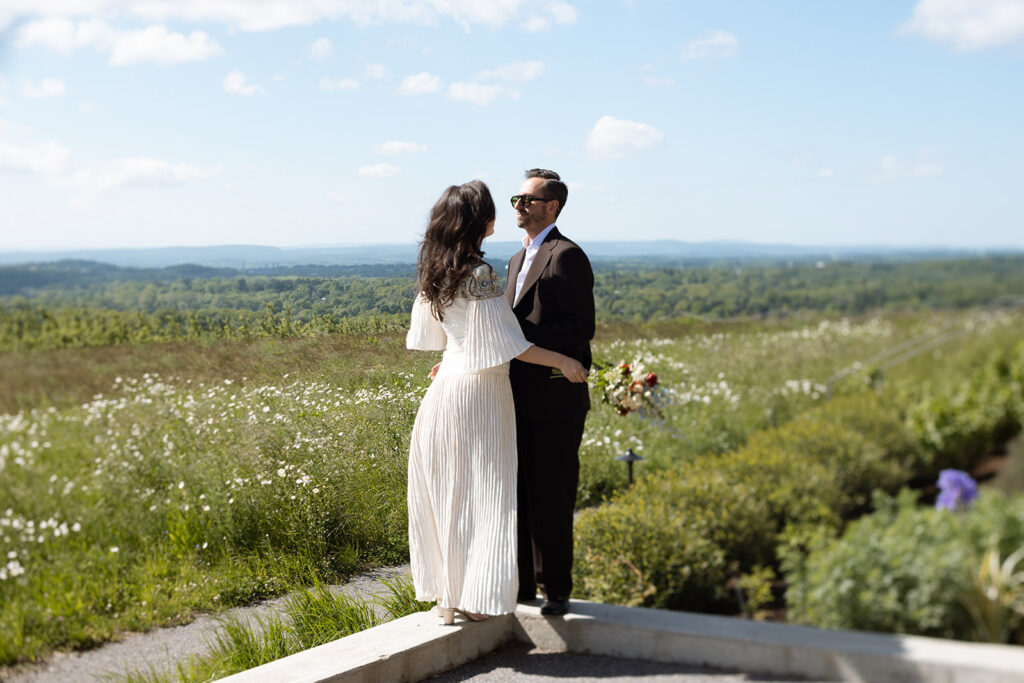 Couple faces each other with the expanse of Hudson Valley behind them on their wedding day.