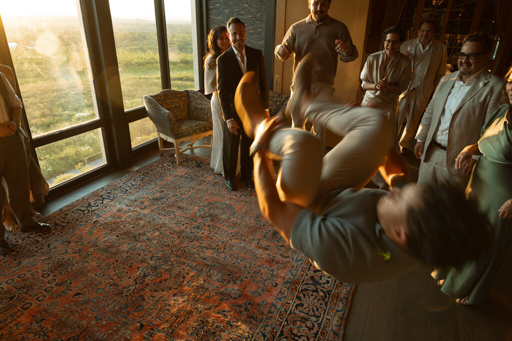 Wedding guest does a backflip while dancing at a wedding reception in upstate New York.