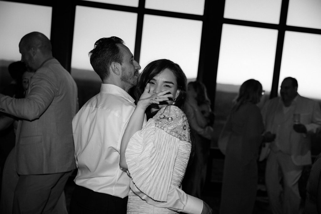 Bride waves at the camera while dancing with her new husband in Hudson, NY. 